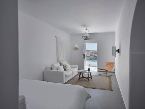 a white living room with a couch and a table at Pietra e Mare - Mykonos Moments in Kalo Livadi