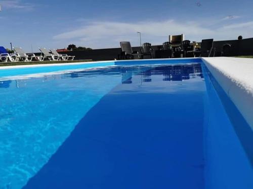 einen großen Pool mit blauem Wasser und Stühlen in der Unterkunft Santiago 2 in Castelo do Neiva