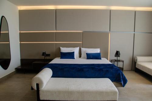 a bedroom with a large bed with blue sheets and pillows at Abi's Hotel & SPA Vlore in Vlorë
