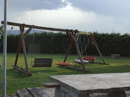 an old swing set in a park with grass at Willa Kolorowa Chata 6 km Od Karpacza in Mysłakowice
