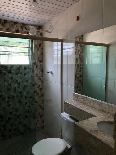 a bathroom with a toilet and a shower and a sink at Vitória Center Plaza Praça in Nova Friburgo