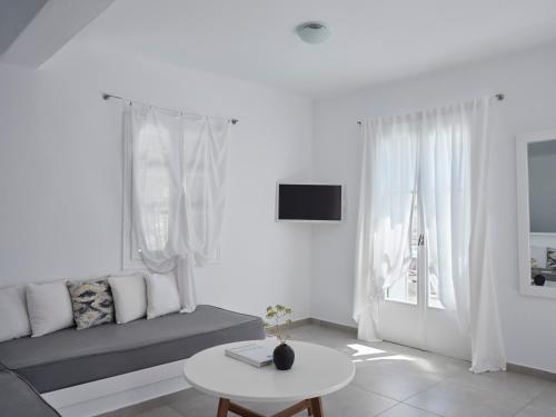 a white living room with a couch and a table at Pietra e Mare - Mykonos Moments in Kalo Livadi