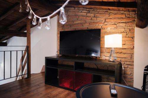 a living room with a television and a brick wall at Mamma Maria P1 in Monterotondo
