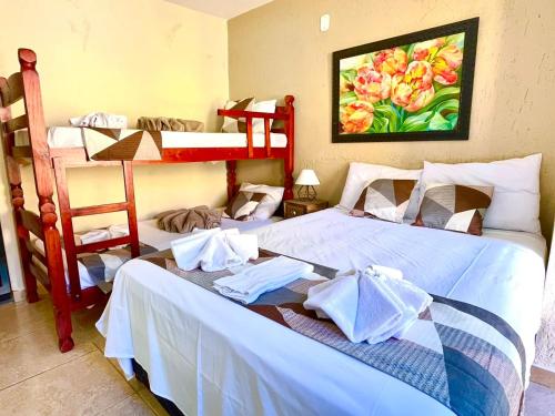 two beds in a room with two bunk beds at Pousada Villa Três in Serra Negra