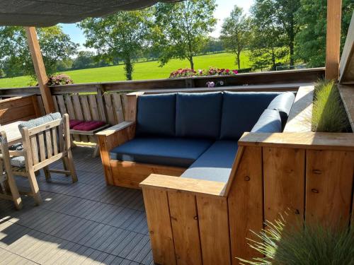 a patio with a couch and a table and chairs at Lenthe Farm Lodge in Dalfsen