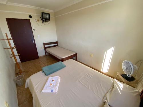 a small room with a bed with a tray on it at Hotel Londe in Patrocínio