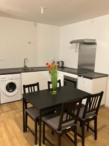une cuisine avec une table avec un vase de fleurs dessus dans l'établissement Agréable T 2 à Evry Courcouronnes, Évry-Courcouronnes