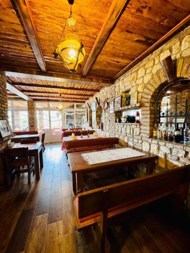 a restaurant with wooden ceilings and tables and chairs at Vila Relax in Dobra Voda
