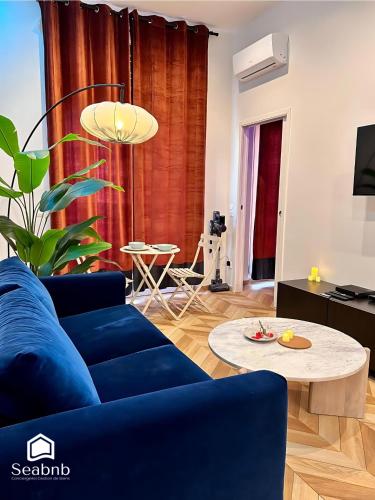 a living room with a blue couch and a table at Luxurious Apartment - Seaside - Spa Bath - WiFi - AC in Nice
