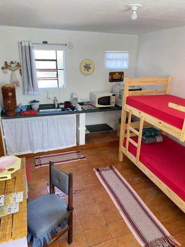 a room with a kitchen and a bunk bed at O Quartim in Passa Quatro