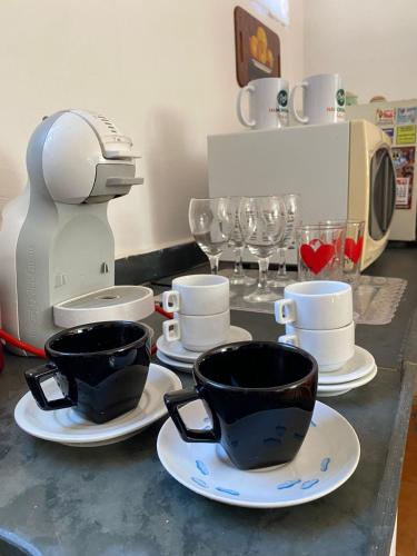 a kitchen counter with two cups on plates and a mixer at O Quartim in Passa Quatro