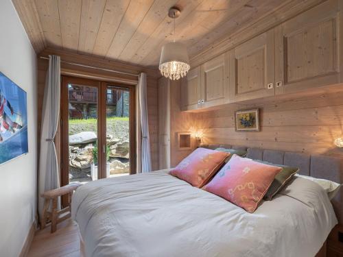 une chambre avec un lit et un lustre dans l'établissement Appartement cosy, proche des pistes à Courchevel, 7 pers, parking, terrasse et WIFI - FR-1-563-25, à Courchevel