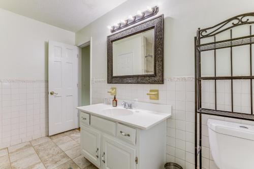 a white bathroom with a sink and a mirror at Alpharetta Home with Patio and Yard about 3 Mi to Downtown in Alpharetta