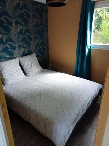 une chambre avec un lit avec des draps blancs et une fenêtre dans l'établissement Gite Nature proche Honfleur, à Fatouville-Grestain