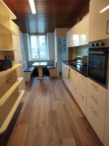a kitchen with white cabinets and a wooden floor at Meiringen holiday in Meiringen