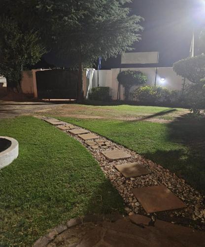 a stone walkway in a yard at night at The Royal Princess B&B on Malibongwe Drive in Johannesburg