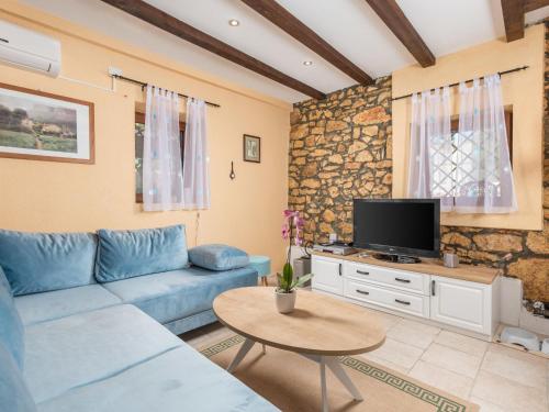 a living room with a blue couch and a tv at Holiday Home Villa Tea by Interhome in Barban