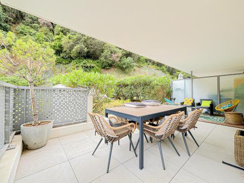 un patio avec une table et des chaises sur un balcon dans l'établissement Canta Galet - Wifi, AC, Parking, 4pers, à Nice