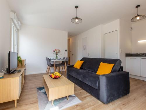 un salon avec un canapé noir et une table dans l'établissement Apartment Cap Océan-4 by Interhome, à Capbreton