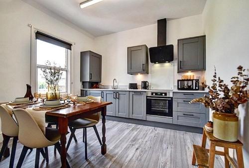a large kitchen with a table and a dining room at Autumn Loft Wyndale Living Malvern Hills in Great Malvern
