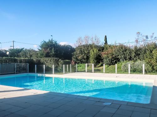 une piscine avec de l'eau bleue dans une cour dans l'établissement Apartment Le Jardin d'Artemis-2 by Interhome, à Saint-Tropez