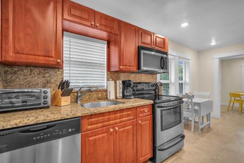 a kitchen with wooden cabinets and a stainless steel appliance at Renovated Grove Bungalow -near Coconut Grove in Miami