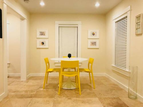 a dining room with a yellow table and chairs at Renovated Grove Bungalow -near Coconut Grove in Miami
