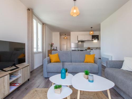 un salon avec un canapé et deux tables dans l'établissement Apartment Cap Océan-18 by Interhome, à Capbreton