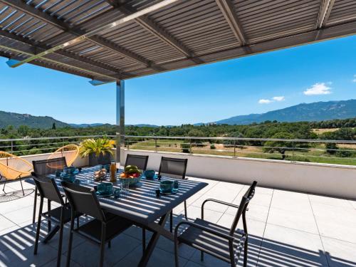 un patio avec une table et des chaises sur un balcon dans l'établissement Apartment Domaine d'Arca-1 by Interhome, à Porto-Vecchio