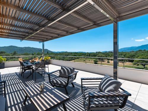 un patio avec une table et des chaises sur un balcon dans l'établissement Apartment Domaine d'Arca-1 by Interhome, à Porto-Vecchio