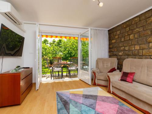 a living room with a couch and a sliding glass door at Apartment Lily by Interhome in Balatonfüred