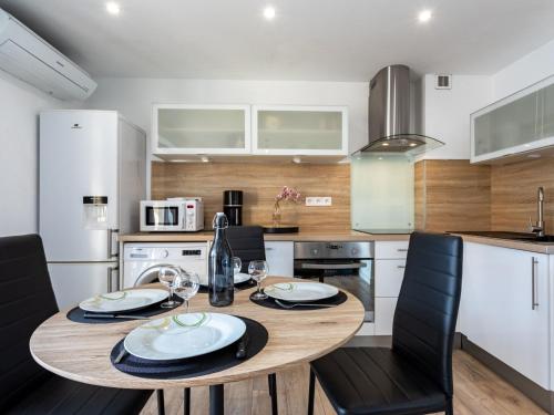 een keuken met een houten tafel en zwarte stoelen bij Apartment Europa by Interhome in Canet-en-Roussillon