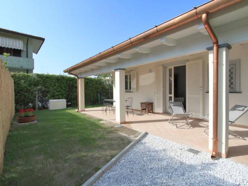 a patio with chairs and a table in a yard at Villa Niccolò by Interhome in Forte dei Marmi