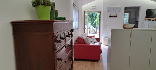 a kitchen with a dresser and a red couch at Casa Giulia in Castelbuono