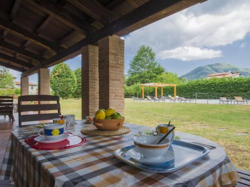 a table with a bowl of fruit on top at Holiday Home La Fenice - 08 pax by Interhome in Camporgiano