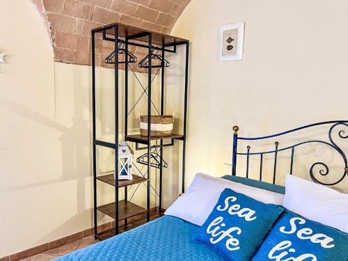 a bedroom with a blue bed and a shelf at Apartment Fattoria Palazzeta by Interhome in La Cinquantina