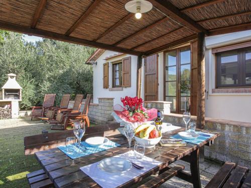 una mesa de madera con un bol de fruta en el patio en Holiday Home La Villetta by Interhome, en Riparbella