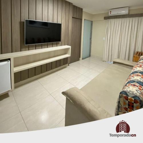 a living room with a flat screen tv on a wall at Piazza diRoma com acesso ao Acqua Park - Luciana in Caldas Novas