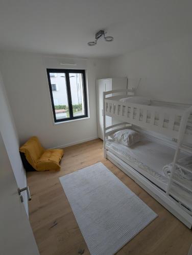 - une chambre avec des lits superposés blancs et une fenêtre dans l'établissement Evasion Plage - Appartement lumineux plein centre et 150m plage, à Neufchâtel-Hardelot