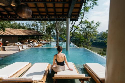 a woman sitting on a pool at a resort at Loi Suites Iguazu Hotel in Puerto Iguazú