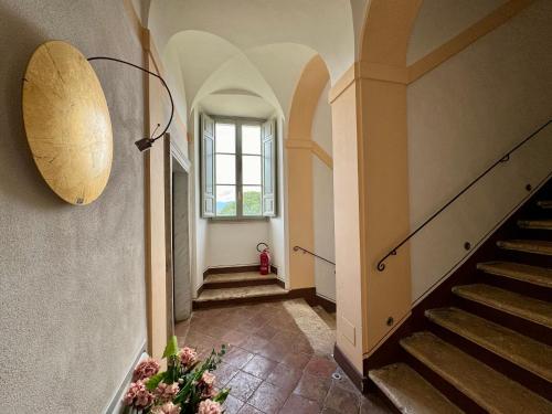 a hallway with stairs and a window and a vase of flowers at Villa Dell'Annunziata in Rieti