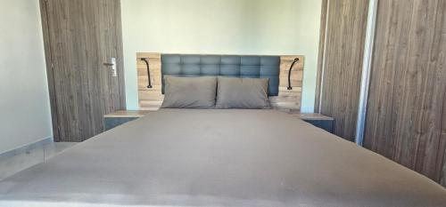 a large bed with a blue headboard in a room at Marina smir Oceanica in Marina Smir