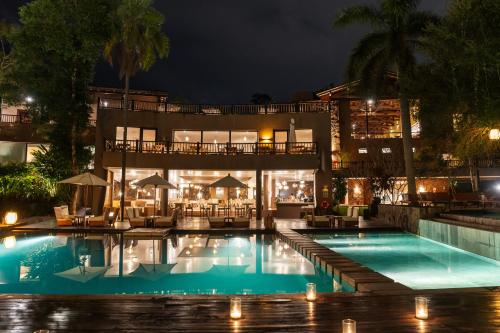 a hotel with a swimming pool at night at Loi Suites Iguazu Hotel in Puerto Iguazú
