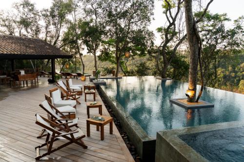 a swimming pool with lounge chairs and a table at Loi Suites Iguazu Hotel in Puerto Iguazú