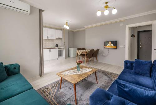 a living room with a blue couch and a table at LOYA APARTMENTs in Trabzon