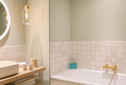 a bathroom with a tub and a sink at A-ROSA Gardasee in Salò