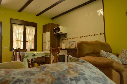 ein Wohnzimmer mit gelben Wänden sowie einem Tisch und Stühlen in der Unterkunft Apartamentos rurales Casa Rosi in Ranón