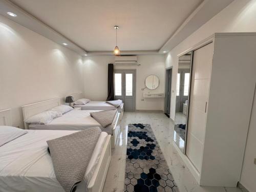 a room with three beds and a mirror at Noya House Dahab in Dahab
