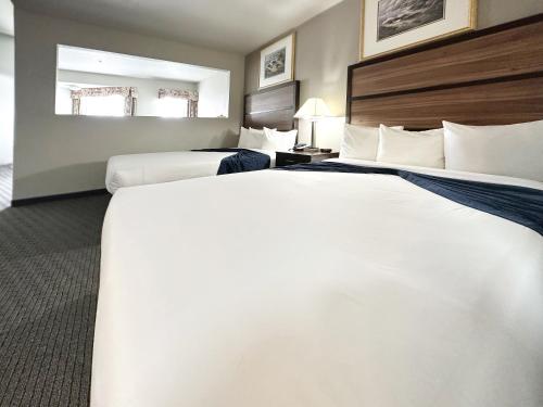 two beds in a hotel room with a large bed at BayVue Hotel, Resort & Suites in Ocean Shores