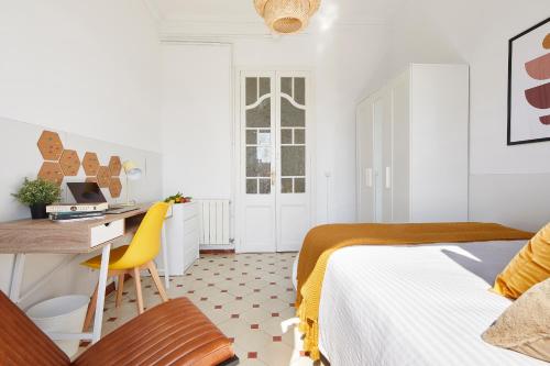 a bedroom with a bed and a desk with a computer at Gran Via - 1 in Barcelona
